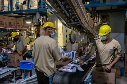 Workers place packages of Fabrica de Jabon La Carona SA Roma brand detergent into boxes at the company's manufacturing facility in Ecatepec de Morelo, Mexico, on Friday, July 2, 2021