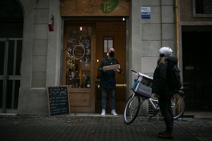 Un dependiente entrega un paquete en una tienda de Barcelona el viernes pasado.