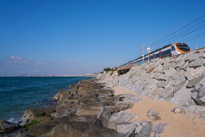 Tren circulant per les vies al costat del litoral al seu pas per Montgat Nord.