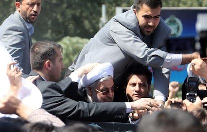 Rohaní, rodeado de sus guardaespaldas a la llegada a Irán.