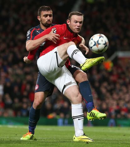 Wayne Rooney con Giannis Maniatis durante el partido.