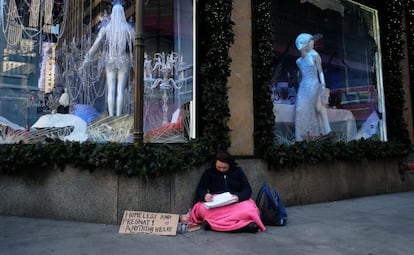 Uma mulher pede esmola na Quinta Avenida.