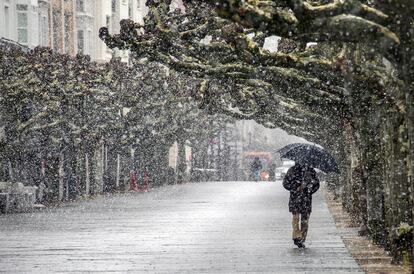 Una persona camina mientras nieva por la calle de Burgos , este jueves. 
