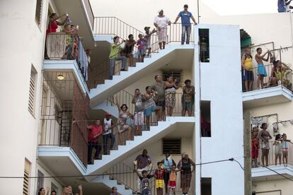 Decenas de personas esperan esperan en los balcones y en las escaleras de un edificio de apartamentos el paso del papam&oacute;vil que lleva a Francisco desde el aeropuerto hasta la ciudad.