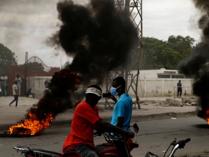 Supporters of former Senator Youri Latortue and Steven Benoit set tires on fire outside the court house in Port-au-Prince, Monday, July 12, 2021. Prosecutors have requested that high-profile politicians like Latortue and  Benoit meet officials for questioning as part of the investigation into the assassination of President Jovenel Moise. (AP Photo/Joseph Odelyn)