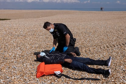 Un policía revisa el estado de un hombre colapsado en la playa de Dungeness el 4 de agosto de 2021.