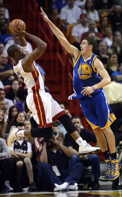 Dwyane Wade, de los Heat, lanza a canasta ante Klay Thompson, de los Warriors