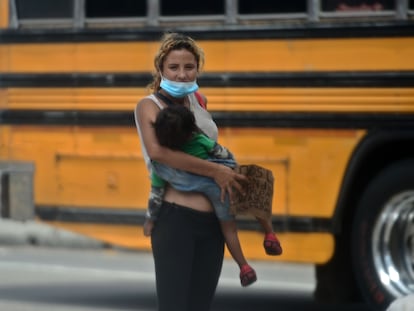 Una mujer con un niño en brazos, pide dinero en las calles de Tegucigalpa, Honduras.