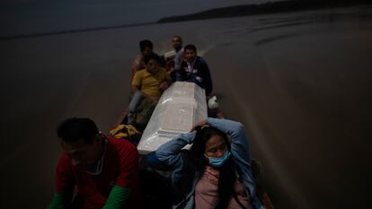 Algunos familiares llevan el feretro de un hombre que murió de complicaciones derivadas de la covid-19 por el río Ucayali de Perú.