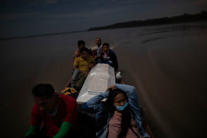 Algunos familiares llevan el feretro de un hombre que murió de complicaciones derivadas de la covid-19 por el río Ucayali de Perú.