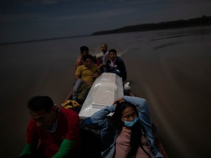 Algunos familiares llevan el feretro de un hombre que murió de complicaciones derivadas de la covid-19 por el río Ucayali de Perú.