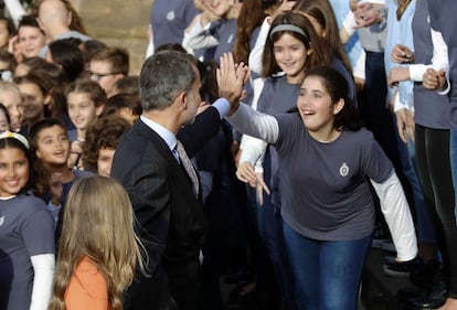 El rey Felipe VI choca la mano a una niña del coro de la Fundación Princesa de Asturias. Mientras la coral ha cantado el himno del Principado, la familia real ha tatareado la letra.