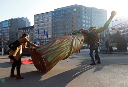 Activistas colocan una estatua de la justicia, durante una protesta frente a la sede de la Comisión de la UE, un día antes de que el Tribunal de Justicia de las Comunidades Europeas decida si el acuerdo de libre comercio entre la UE y Canadá está en línea con la legislación de la UE, en Bruselas (Bélgica).