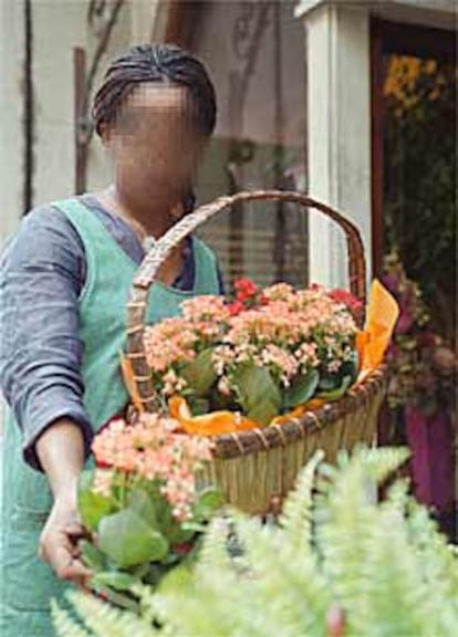 Una niña africana vende flores en una tienda de Zaragoza.