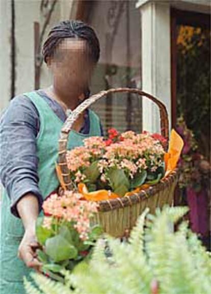 Una niña africana vende flores en una tienda de Zaragoza.