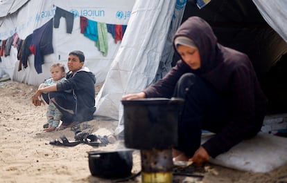 Una mujer palestina, desplazada en Rafah, en el sur de la Franja, cocina frente a la tienda de campaña en la que viven, el 6 de marzo de 2024