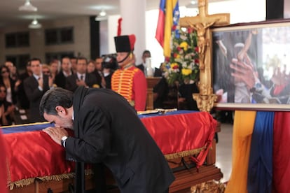 El presidente de Irán, Mahmoud Ahmadinejad,besa la bandera venezolana que cubre el féretro de de Hugo Chávez durante el funeral de Estado.