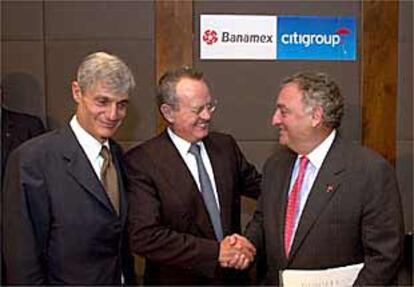 Sandy Weill (a la derecha), presidente de Citigroup, estrecha la mano a Roberto Hernández, tras la compra de Banamex.