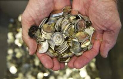 Un hombre sostiene varias monedas de euro letonas en Stuttgart, Alemania. EFE/Archivo