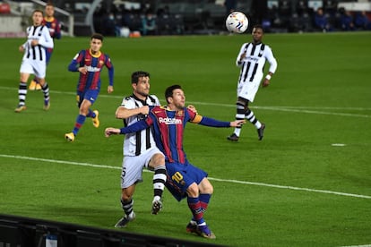 Lionel Messi del Barcelona es sujetado por Sergio Postigo del Levante en un lance del partido.