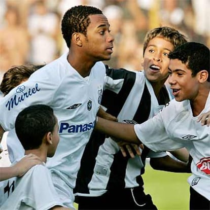 En los últimos partidos que está jugando Robinho con el Santos, la afición responde a la simpatía del jugador con el cariño que recoge esta imagen del delantero rodeado de niños seguidores dl nuevo mitop del fútbol de Brasil.