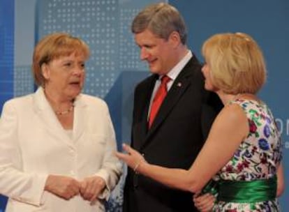 En la imagen, el primer ministro canadiense, Stephen Harper (c), y su esposa, Laureen (d), dan la bienvenida a la canciller alemana, Angela Merkel, durante la cumbre del G20 en Toronto (Canadá). EFE/Archivo