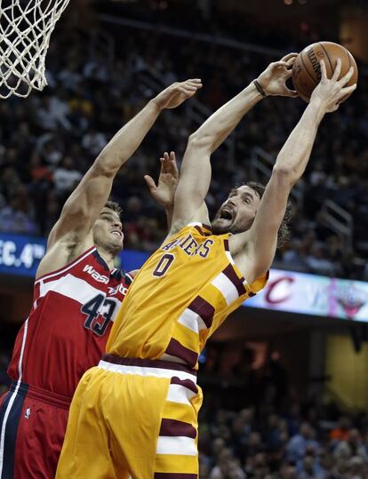 Kris Humphries trata de bloquear una entrada de Kevin Love.