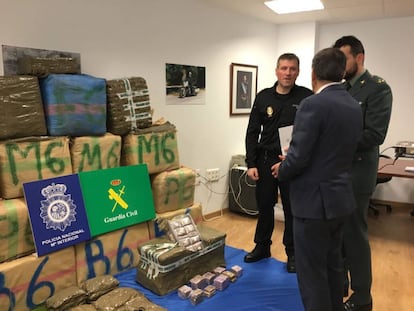 Representantes de la policía y la Guardia Civil ante el alijo incautado.