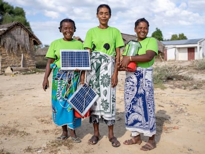 Marie (izquierda), Marinasy (centro) y Tsiampoizy (derecha) son tres mujeres de Ranomay. En la foto, muestran los paneles y las lámparas solares que ellas mismas instalan y reparan. Viajaron hasta India para formarse como ingenieras solares.