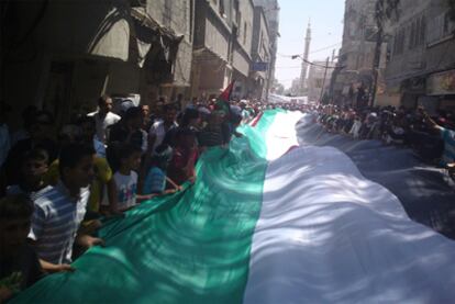 Los opositores al régimen sostienen una bandera siria en una protesta en las calles de Hajar al-Aswad, en Damasco, en una imagen tomada el pasado 17 de julio.