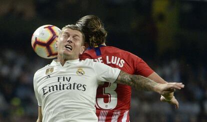 Toni Kroos, del Real Madrid, y Filipe Luis, del Atlético de Madrid, golpean la pelota de cabeza