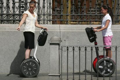 Dos turistas pasean con vehículos Segway en Madrid
