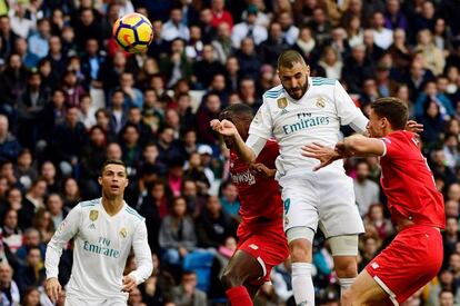 Karim Benzema, defensa francés del Real Madrid, golpea el balón de cabeza.