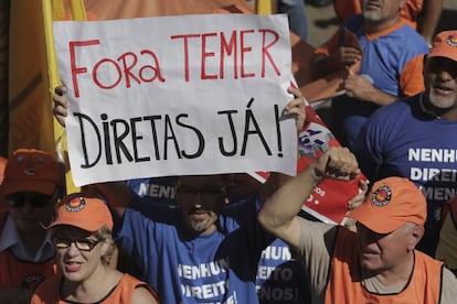 Un protestante sujeta una pancarta que dice: 'Fuera Temer, elecciones directas ya' durante las protestas.