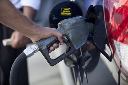 Un hombre pone gasolina en su coche.