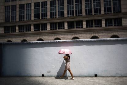 Una mujer pasea bajo el sol de Shanghái, China.