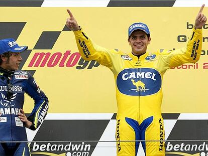Valentino Rossi observa, brazos en jarras, la felicidad de Alex Barros en el peldaño superior del podio.