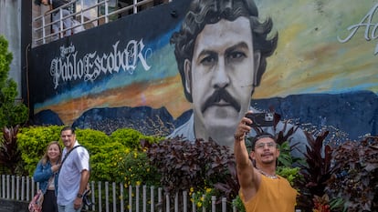 Varios turistas recorren las calles del barrio Pablo Escobar y se hacen fotos con los murales, en Medellín, Colombia, el 21 de noviembre de 2023.