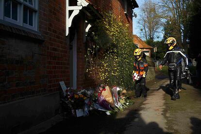 Dos motoristas depositan un ramo de flores en un altar improvisado en el exterior de la casa del cantante George Michael. El artista ha muerto en su hogar a los 53 años.