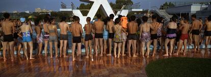 8 de agosto 2012, los norcoreanos se reúnen bajo una plataforma de trampolín para ver como compañeros nadadores dudan en probar una inmersión en una piscina de reciente apertura en Pyongyang, Corea del Norte.