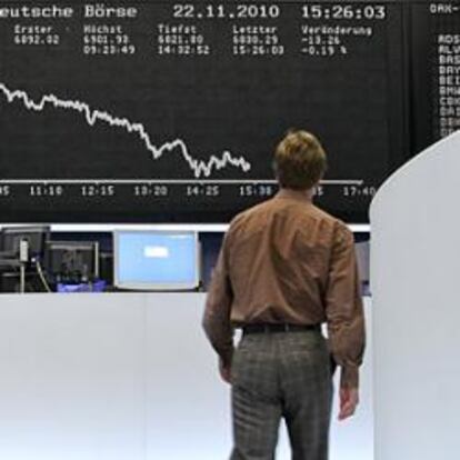 Un operador de Bolsa frente a la pantalla de cotización del índice Dax de Fráncfort