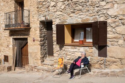 La vecina Mari Carmen Mesto, sentada en la entrada de su casa en Horcajuelo de la Sierra.
