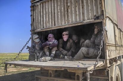 Combatientes del Estado Islámico y sus familias abandonan Baghouz, al norte de Siria, en la parte trasera de un camión, 