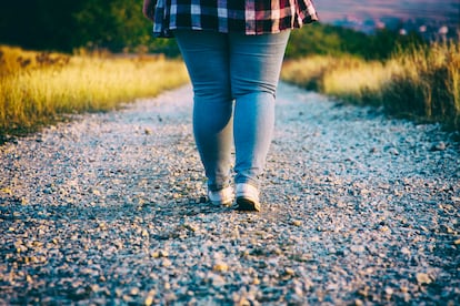 Una chica camina por un sendero empedrado