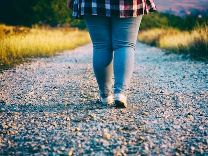 Una chica camina por un sendero empedrado