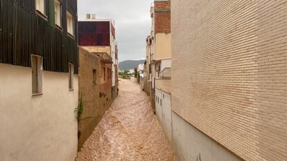 Flood waters run through a street following heavy rains in Alcanar.