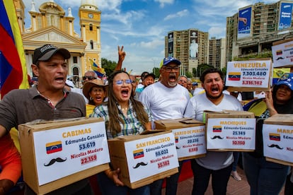 Asistentes a la protesta de Maracaibo sostienen cajas que simulan ser urnas electorales, para protestar contra los resultados del pasado 28 de julio. 