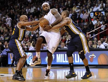 Jamaal Tinsley y and Randy Foye, de los Jazz, intentan frenar el avance de LeBron.