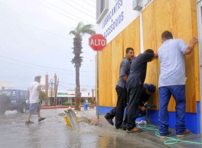 Un grupo de hombres refuerza las paredes de un local comercial en la localidad turística de Los Cabos, en Baja California, ante la llegada del huracán Jimena