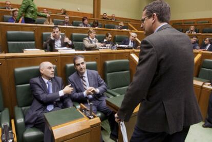 El presidente del PP vasco, Antonio Basagoiti (de pie), habla en un momento del pleno de ayer con el consejero de Interior, Rodolfo Ares (sentado a la izquierda) y el portavoz parlamentario popular, Leopoldo Barreda.